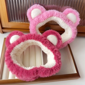 Detail of pink plush bear-ear headband on wooden tray for face washing and skincare