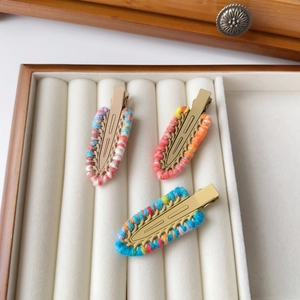 Detailed macro view of three knitted yarn crochet hair clips on velvet tray