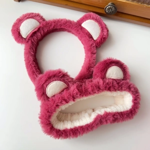 Close-up of pink plush bear headband and elastic hairband with soft texture