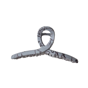 Matte grey shark hair claw clip with black marble patterns on white background