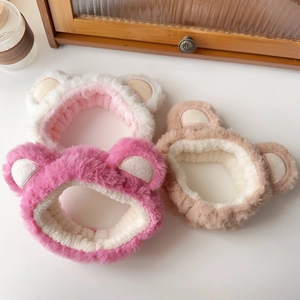 Close-up of plush bear ear headbands in white, rose red, and brown for face washing
