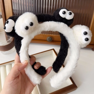 Close-up of soft plush soot sprite headbands with cute large eyes in black and white