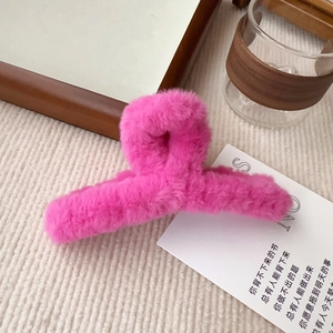 Detailansicht einer rosa Plüsch-Haarklammer in einer gemütlichen Lifestyle-Szene