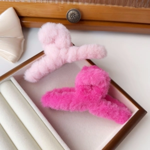 Detailed view of large plush hair claw clips in light pink and hot pink faux fur