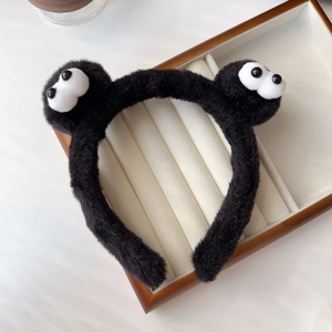 Detail showing the fluffy texture and large eyes of the black plush headband