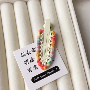 Close-up of colorful woven wool texture on a sweet style duckbill hair clip