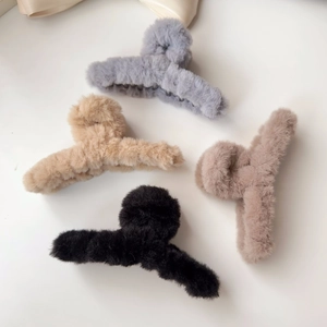 Detail view of four plush claw clips in grey, beige, brown, and black for autumn hairstyle