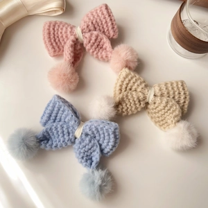 Détails des barrettes à nœuds tricotés avec pompons doux en rose, beige et bleu