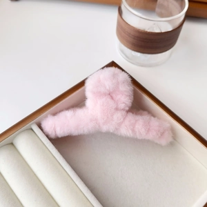 Detailed view of a soft light pink plush claw clip on a tray with aesthetic background
