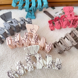 Matte oversized wavy shark hair clips in six colors including blue and grey marble