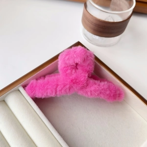 Detail of soft pink plush hair claw clip displayed on a premium beige velvet tray