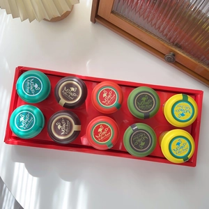 Set of 10 colorful candy-toned hair tie jars neatly arranged on a red serving tray