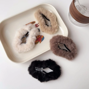 Dettaglio di fermagli per capelli a stella in peluche nei colori beige e marrone