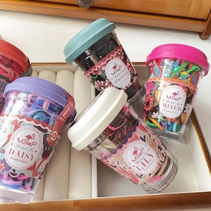 Detail of colorful mini hair ties in creative drink cup packaging on display
