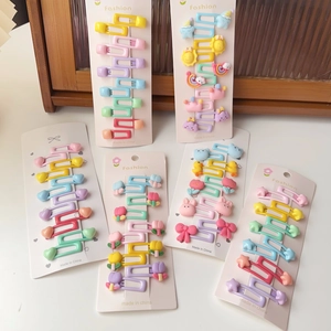 Vue détaillée de lots de barrettes colorées avec motifs cœur, arc-en-ciel et animaux