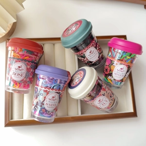 Detailed top view of five colorful elastic hair bands in vintage floral cups on a tray