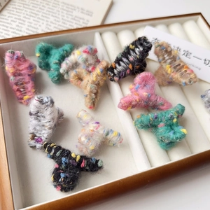 Gros plan de mini pinces à cheveux en tricot avec fils colorés dans une boîte