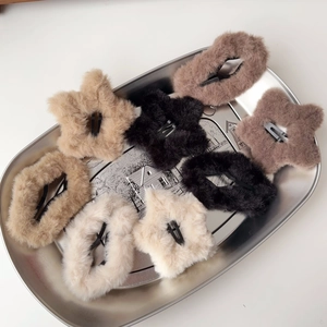 Dettaglio dei fermagli per capelli in peluche a forma di stella su un vassoio d'argento