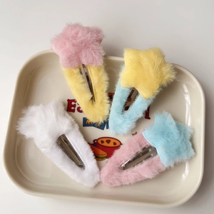 Détail de barrettes en peluche en forme d'étoile aux tons pastel sur un plateau