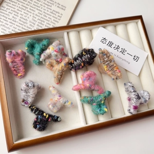 Mini pinces à cheveux en tricot coloré pour femmes disposées sur un plateau chic