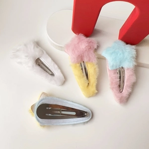 Détail de quatre barrettes à cheveux en peluche en forme d'étoile sur fond blanc