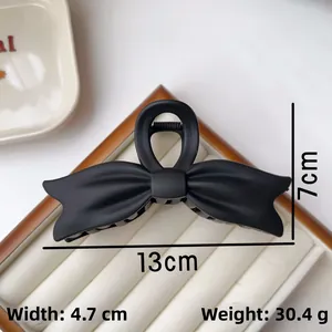 Detail view of large black matte bow hair claw clip with dimensions 13cm x 7cm