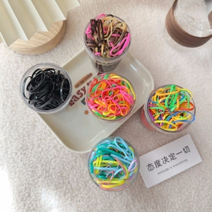 Detailed view of 5 cans of colorful elastic hair bands in macaron and rainbow shades