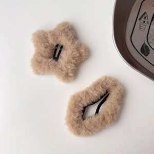 Dettaglio di fermagli per capelli a stella in peluche kaki con morbida ecopelliccia