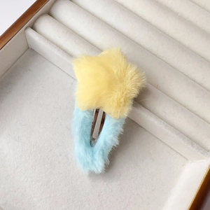 Détail macro d'une pince à cheveux étoile en peluche douce aux tons macaron