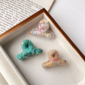 Lot de trois mini pinces à cheveux en laine tricotée de couleurs crème et verte