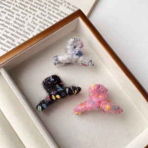 Détail de mini pinces à cheveux en tricot pelucheux sur fond de livre vintage style