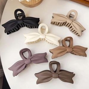 Detailed collection of six matte oversized bow hair claws in various elegant Morandi tones