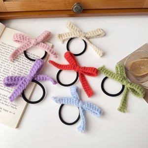 Sechsteiliges Set gestrickter Haargummis mit Schleifen in Pastellfarben auf weißem Untergrund