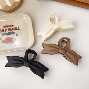Three-piece set of elegant matte bow hair claws in black, brown, and cream white colors