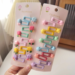 Gros plan de barrettes bébé en forme de tulipe et étoile aux couleurs macaron vives