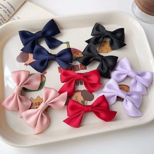 Detailed macro view of colorful ribbon bow hair clips set in a decorative tray
