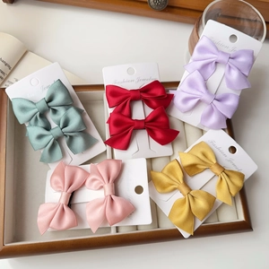 Detailed view of colorful satin bow hair clips set on display cards in a jewelry box