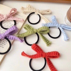 Detail von bunten handgestrickten Bogenhaarbändern mit weicher Garntextur und Gummiband