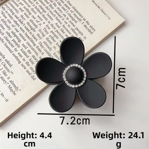 Detail showing matte black flower hair claw clip with rhinestones and precise dimensions