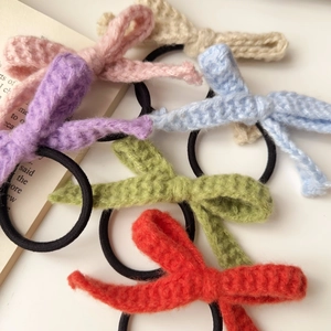 Detailansicht von sechs bunten gestrickten Schleifen-Haargummis auf weißem Hintergrund