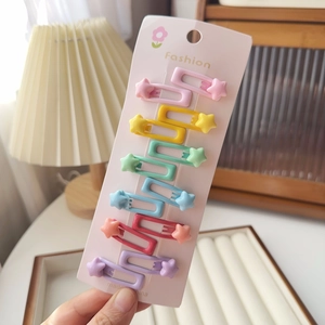 Gros plan de douze barrettes colorées en forme d'étoile pour filles sur carte