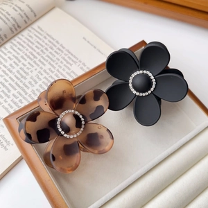 Chic leopard and black floral hair claws with rhinestones on a decorative tray