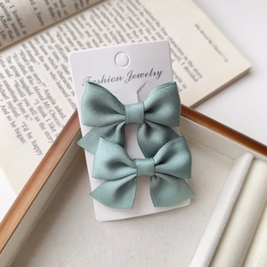 Close-up of light blue satin ribbon bow hair clips on jewelry display card