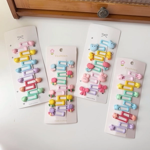 Détail de barrettes à cheveux colorées aux tons macaron avec motifs cœur et ours