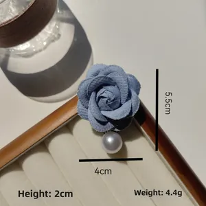 Détail d'une broche camélia en tissu bleu avec perle, hauteur 2cm, poids 4,4g