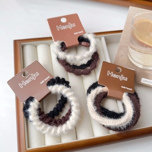 Set di tre elastici per capelli in peluche nei colori neutri crema, marrone e nero