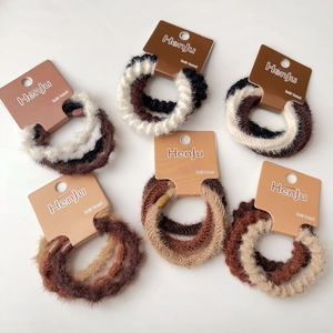 Primo piano di elastici per capelli in peluche dai toni della terra con confezione card