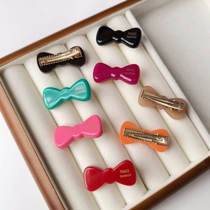 Détail des barrettes nœuds en acétate avec inscription dorée France Handmade en boîte