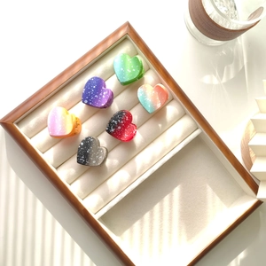 Mini heart hair claws set in gradient colors with white speckled dots on wood tray