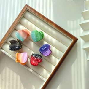 Macro shot of colorful gradient heart hair claws with polka dots on a display tray